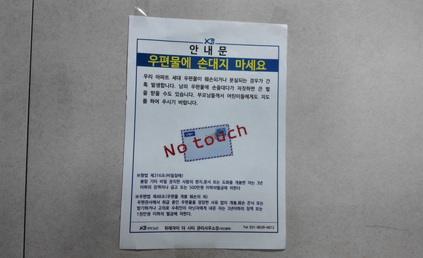 LH가 공급한 성남 위례자이더시티 아파트 스마트우편함 옆에 부착된 '우편물 분실·훼손' 경고 안내문. 최첨단 시스템을 내세운 장비 바로 옆에 아날로그 방식의 경고문이 붙어있는 모습은, 스마트우편함의 보안 기능이 제 역할을 못 하고 있음을 보여주는 단적인 예다.